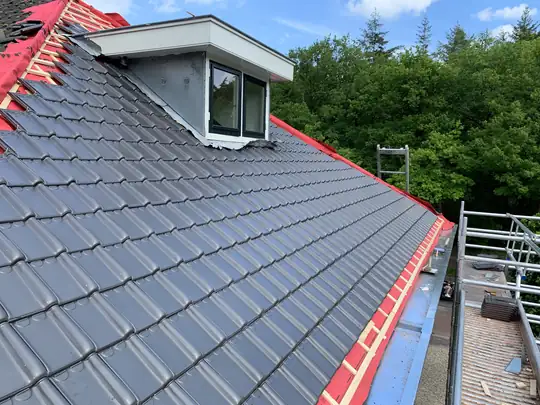 Schuin dak met nieuwe dakpannen, uitgevoerd door dakdekker in Noord-Nederland